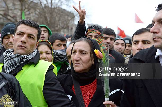 Woman holds a flower as she takes part in a demonstration with hundreds of people of Kurdish origin, on January 12, 2013 in Paris, two days after...