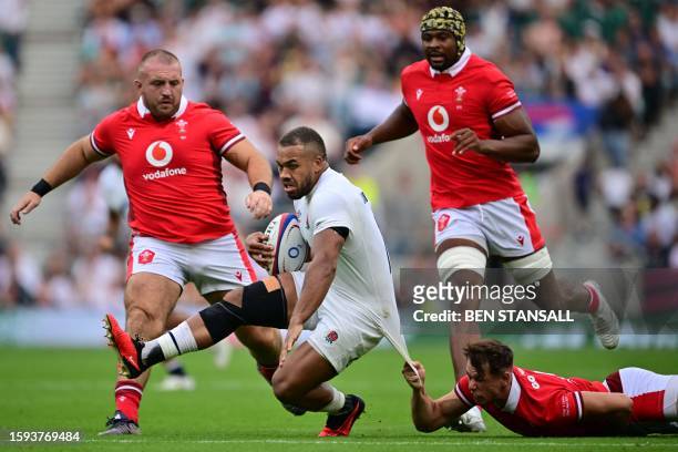England's centre Ollie Lawrence is pulled back during the Summer Series international rugby union match between England and Wales at Twickenham...
