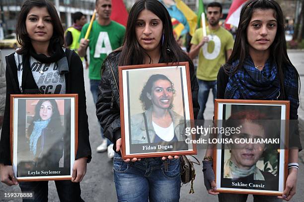 Kurdish demonstrators hold pictures of the three Kurdish activits found shot dead at the Kurdistan Information Bureau in Paris, during a protest in...