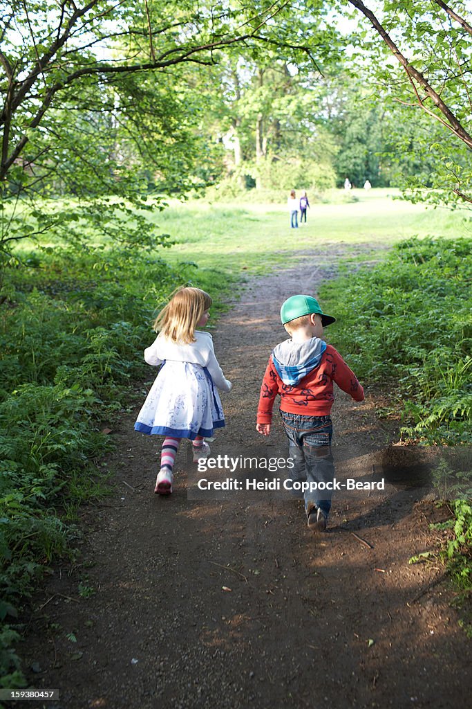 Two children walking through forest