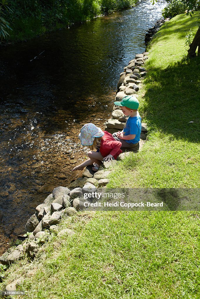 Two children playing by the river