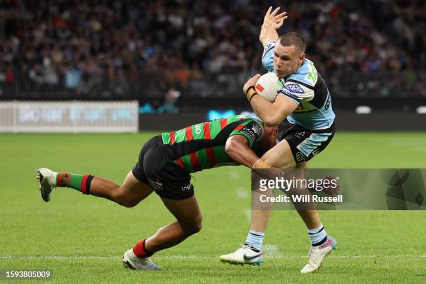 Connor Tracey of the Sharks is tackled by Isaiah Tass of the Rabbitohs during the round 23 NRL match between South Sydney Rabbitohs and Cronulla...