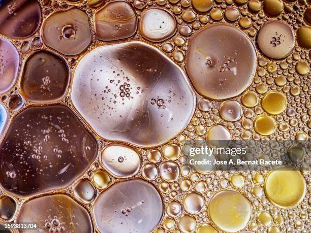 full frame of round bubbles of liquid in circular motion collide and mix. - cell structure stock-fotos und bilder
