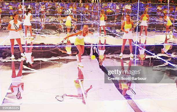 Laura Robson of Great Britain and Maria Kirilenko of Russia watch as Caroline Wozniacki of Denmark plays a shot on a mirror court at the Adidas by...