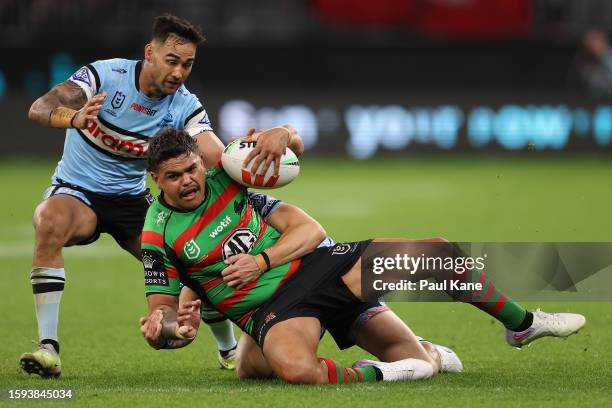 Latrell Mitchell of the Rabbitohs gets tackled by Nicholas Hynes of the Sharks during the round 23 NRL match between South Sydney Rabbitohs and...