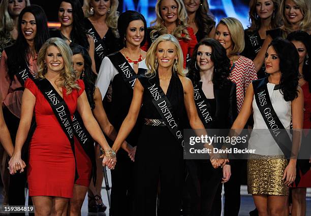 Alyssa Murray, Miss Delaware, Allyn Rose, Miss District of Columbia and Leighton Jordan, Miss Georgia hold hands during the 2013 Miss America Pageant...