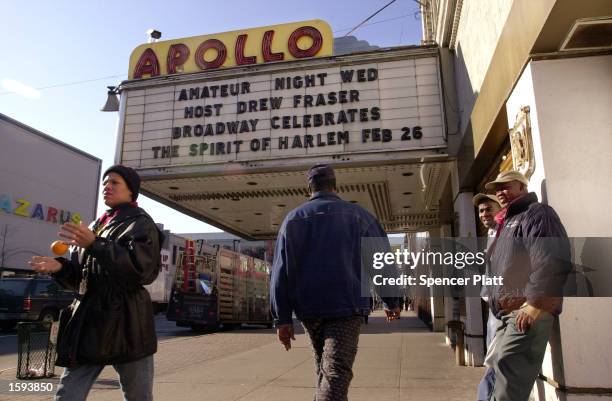 Pedestrians walk by the famous Apollo theater on 125th Street in Harlem, New York February 13, 2001 after former President Bill Clinton stated his...