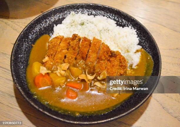 eating japanese food at a restaurant curry dish - japanese curry stock pictures, royalty-free photos & images