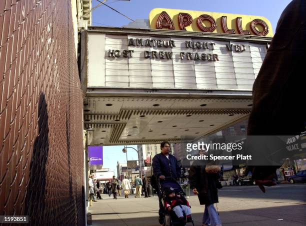 Pedestrians walk by the famous Apollo theater on 125th Street in Harlem, New York February 13, 2001 after former President Bill Clinton stated his...