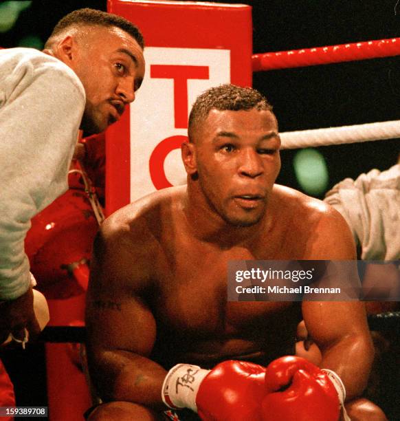 With his left eye closed, American boxer Mike Tyson prepares to come out for the seventh round during his world heavyweight title fight against James...