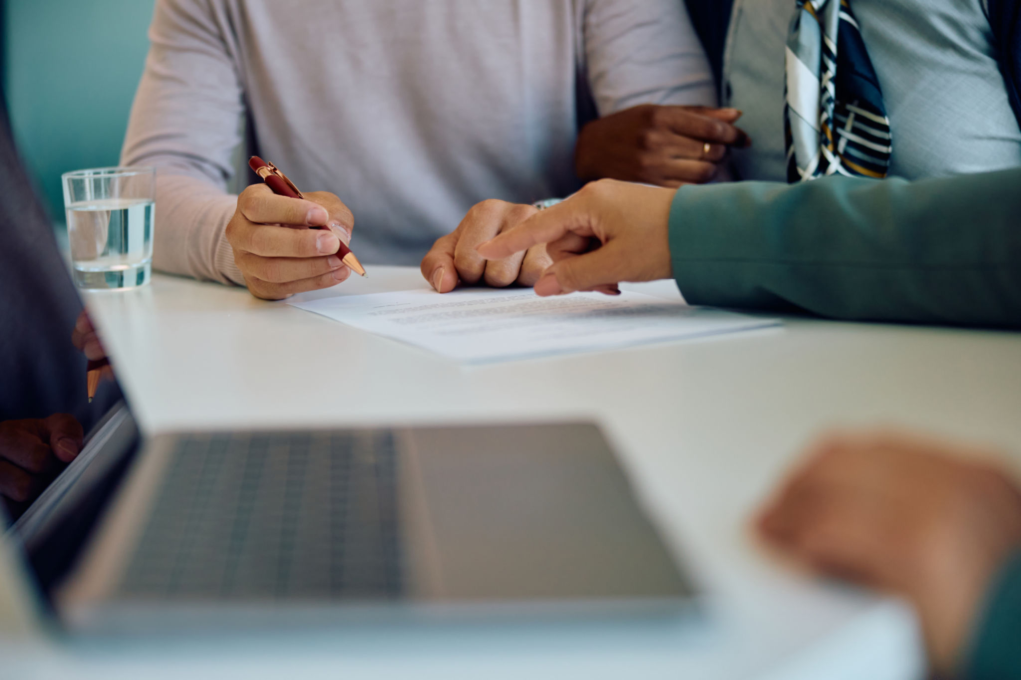 Close up of couple signing an agreement with bank manager in the office. Close up of couple signing an agreement with bank manager in the office.