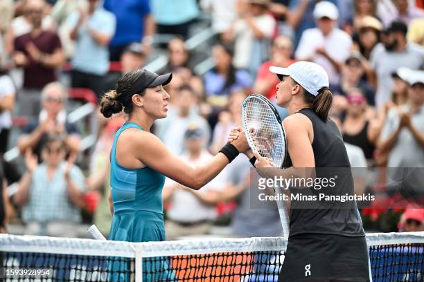 Jessica Pegula of the United States of America and Iga Swiatek of Poland lock hands at the net after their match on Day 6 during the National Bank...