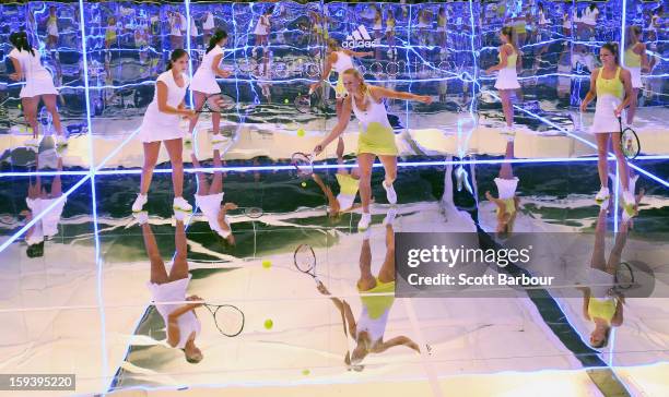 Laura Robson of Great Britain and Maria Kirilenko of Russia watch as Caroline Wozniacki of Denmark plays a shot on a mirror court at the Adidas by...