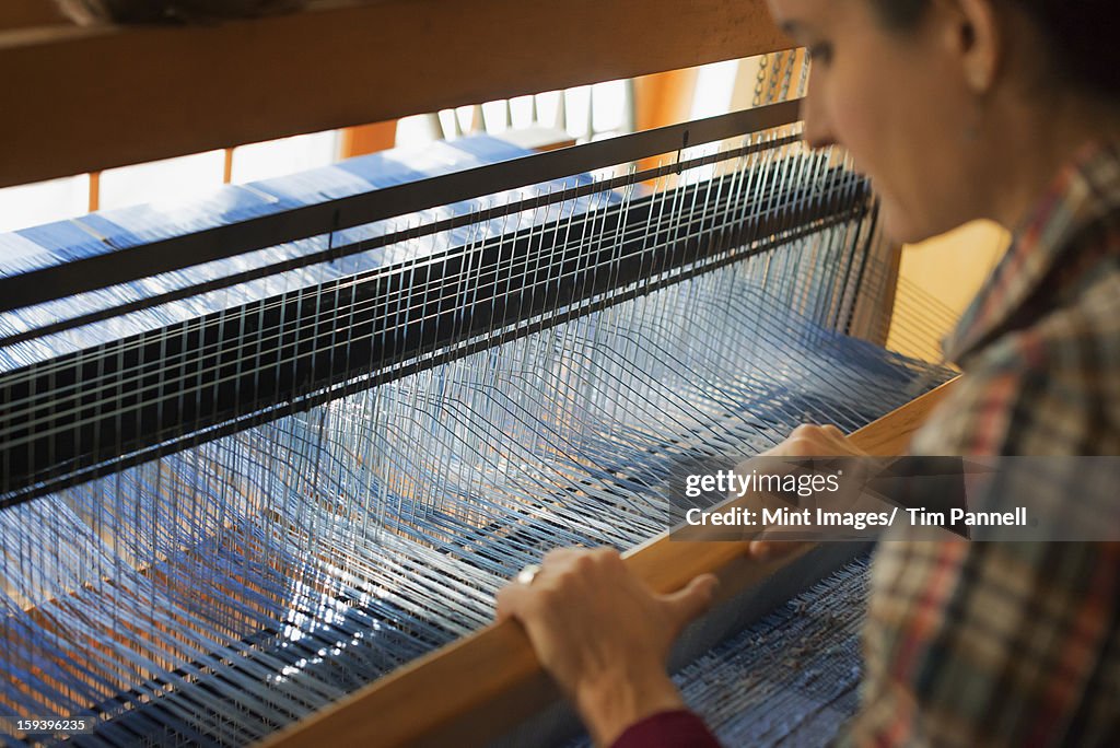 Une femme assis sur un bois pour créer un tisserand woolle tissé à la main