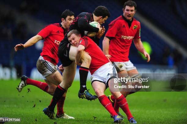 Edinburgh player Matt Scott is tackled by the Munster centre Keith Earls during the Heineken Cup Round 5 match between Edinburgh and Munster at...