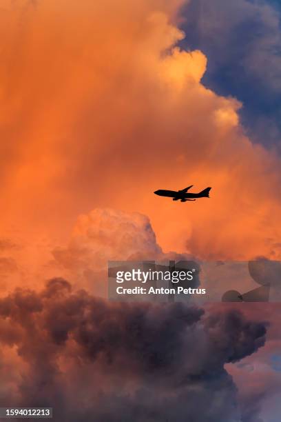 airplane at sunset against a background of thundercloud - airport rain stock-fotos und bilder