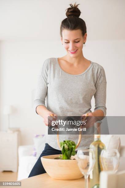 woman preparing salad in kitchen - salatschüssel stock-fotos und bilder