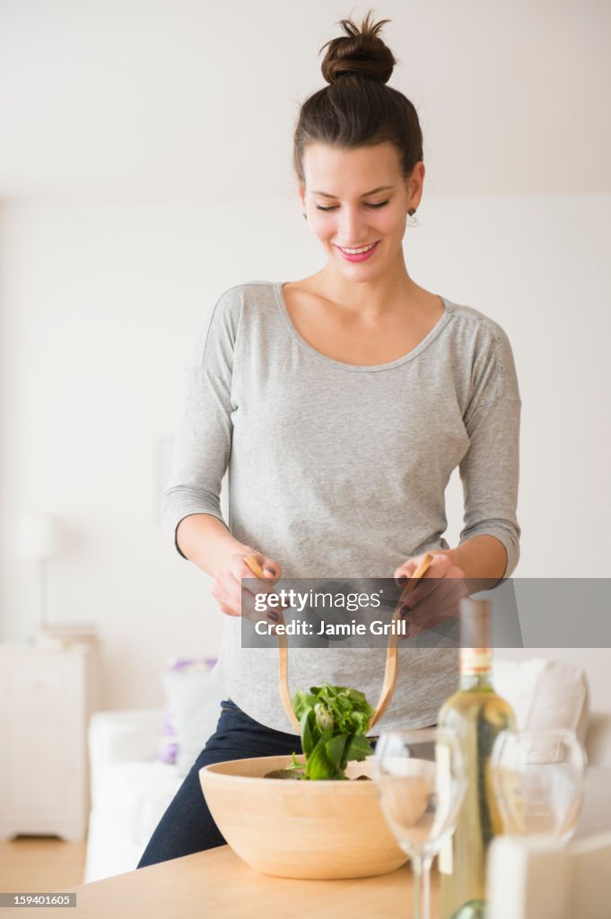 Woman preparing salad in kitchen