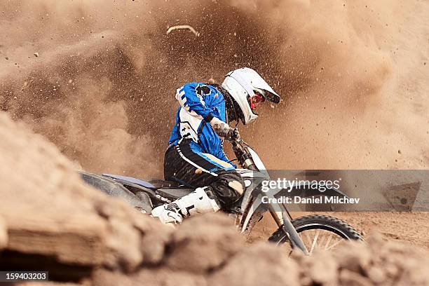 motocross biker taking a turn in the dirt. - adrenalin stock-fotos und bilder