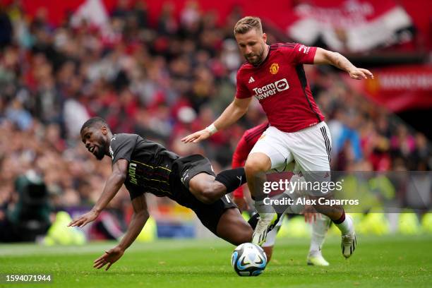 Luke Shaw of Manchester United is challenged by Kevin Danso of RC Lens during the pre-season friendly match between Manchester United and RC Lens at...