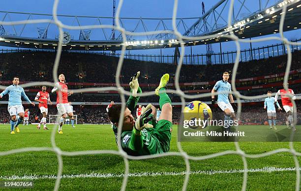 Wojciech Szczesny of Arsenal saves a penalty from Edin Dzeko of Manchester City during the Barclays Premier League match between Arsenal and...