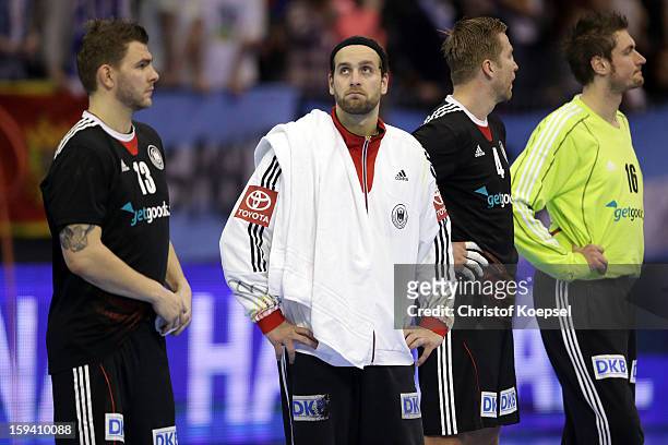 Christoph Theuerkauf, Silvio Heinevetter, Oliver Roggisch and Carsten Lichtlein of Germany look dejected after the premilary group A match between...