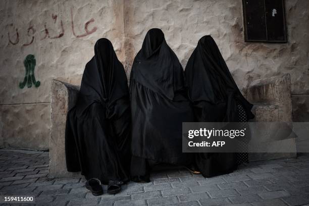 Bahraini Shiite Muslim women sit during the funeral of Habib Ebrahim Abdullah on January 13, 2013 in the village of Malikiyah, south of Manama....