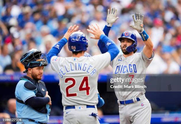 Dansby Swanson of the Chicago Cubs celebrates his three-run home run with Cody Bellinger against the Toronto Blue Jays during the fourth inning in...