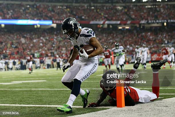 Golden Tate of the Seattle Seahawks runs a reception in for a third quarter touchdown against the defense of Thomas DeCoud of the Atlanta Falcons...