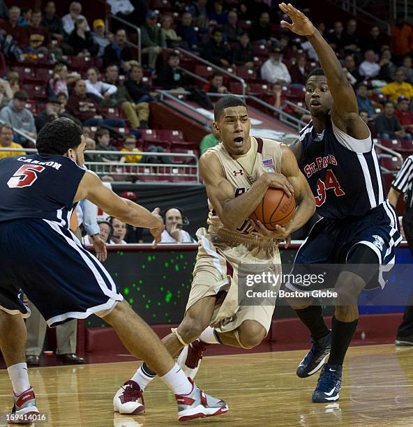 Boston College Eagles player Lonnie Jackson drives to the basket in between St. Francis Terrier Jalen Cannon, left, and Kevin Douglas during second...