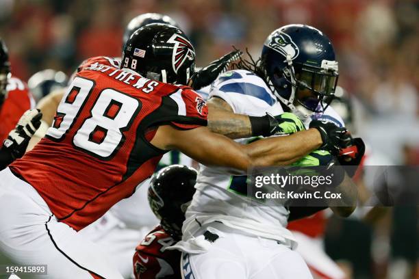 Cliff Matthews of the Atlanta Falcons tackles Marshawn Lynch of the Seattle Seahawks during the NFC Divisional Playoff Game at Georgia Dome on...