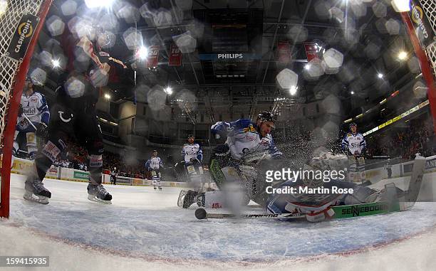 Andreas Morczinietz of Hannover celebrates his team's 4th goal while Jason Bacashihua , goaltender of Straubing looks dejected during the DEL match...