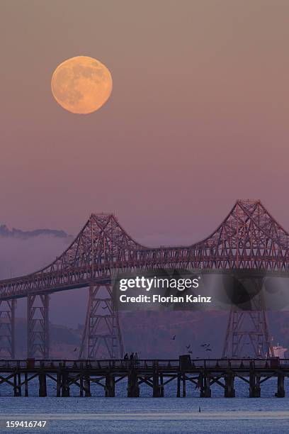 August 1, 2012 - the full Moon rises to the east of the Richmond San Rafael Bridge. The bridge, which crosses the San Francisco Bay in California, is...
