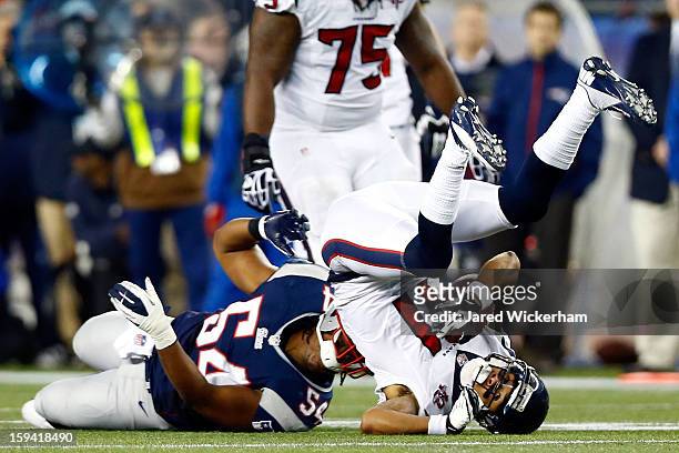 Dont'a Hightower of the New England Patriots tackles DeVier Posey of the Houston Texans during the 2013 AFC Divisional Playoffs game at Gillette...