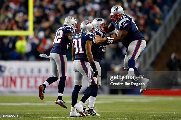 Rob Ninkovich of the New England Patriots celebrates with Vince Wilfork, Aqib Talib and Devin McCourty after making an interception in the third...