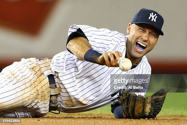 Derek Jeter of the New York Yankees reacts after he injured his leg in the top of the 12th inning against the Detroit Tigers during Game One of the...
