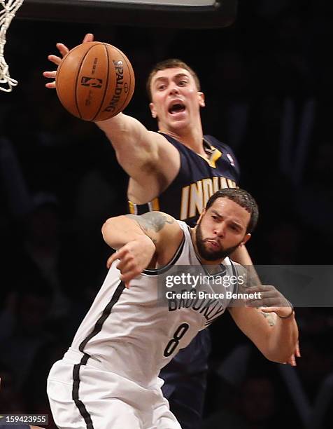 Tyler Hansbrough of the Indiana Pacers punches the ball away from Deron Williams of the Brooklyn Nets at the Barclays Center on January 13, 2013 in...