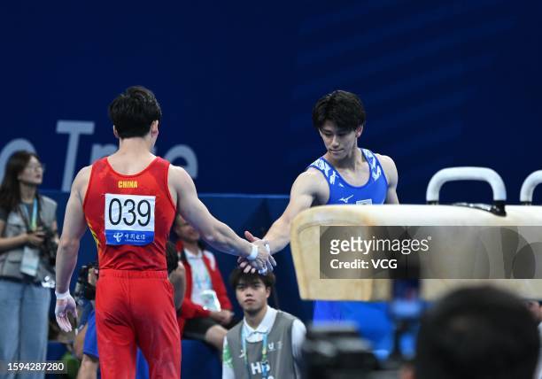 Zhang Boheng of Team China shakes hands with Daiki Hashimoto of Team Japan in the Artistic Gymnastics - Men's Individual All-Around Final on day 7 of...