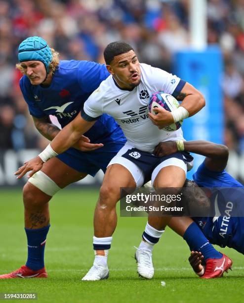 Sione Tuipulotu of Scotland is tackled by France players Bastien Chalureau and Yoan Tanga during the Summer International match between Scotland and...