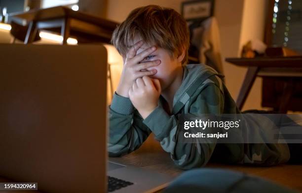 jeune enfant regardant des films sur l’ordinateur portable - cyber harcèlement photos et images de collection