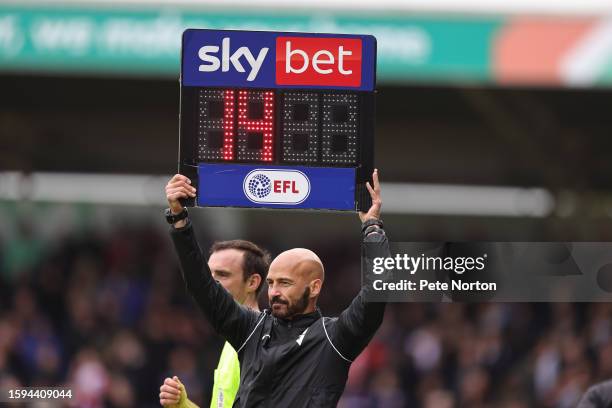 Fourth Official Darren Drysdale holds aloft the Substitutes board to show 14 minutes added time in the second half during the Sky Bet League One...