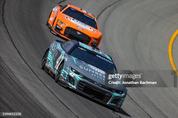 Josh Berry, driver of the Sunseeker Resort Chevrolet, and Kevin Harvick, driver of the Busch Light Peach Ford, drive during practice for the NASCAR...