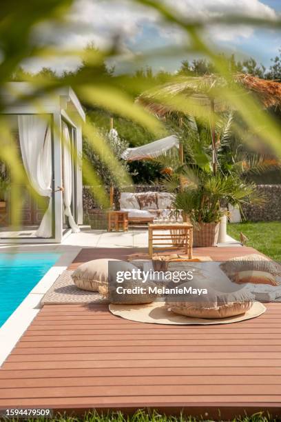 espace piscine privée dans jardin bohème extérieur avec chaises longues sur terrasse en bois et pool house - pergola bois photos et images de collection
