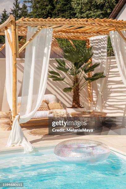 canapé d’extérieur en bambou boho sous pergola en bois flotté au bord de la piscine au soleil chaud - pergola bois photos et images de collection
