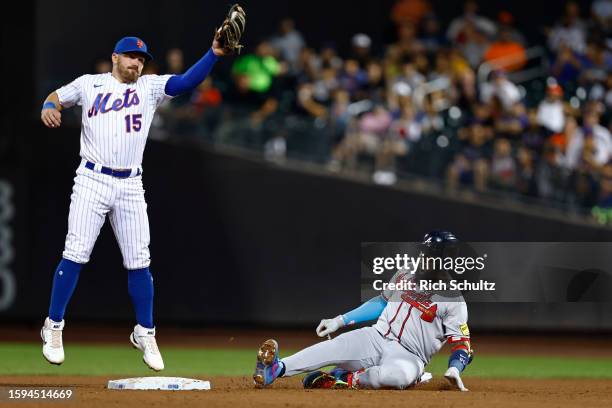 Marcell Ozuna of the Atlanta Braves slides in to second base safely with a double as second baseman Danny Mendick of the New York Mets jumps to catch...