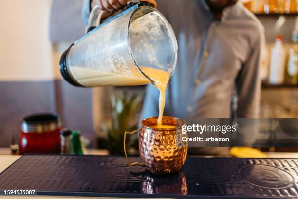 bartender preparing piña colada cocktail at a bar - master blender stock pictures, royalty-free photos & images