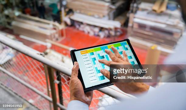 close-up on a foreperson using a digital tablet to control the stock of wood at a batten factory - batten stock pictures, royalty-free photos & images