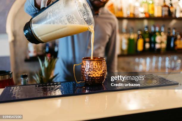 bartender preparing piña colada cocktail at a bar - cocktail party work stock pictures, royalty-free photos & images