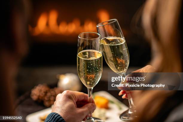 back of head close up of couple cheering with champagne glasses - champagneglas stock-fotos und bilder