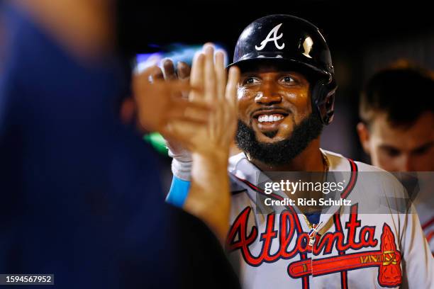 Marcell Ozuna of the Atlanta Braves is congratulated after scoring on a single by Kevin Pillar against the New York Mets during the fifth inning in...